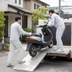 岐阜県で原付バイクを不用品回収トラックに積み込む作業員のイメージ