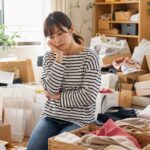 買い物依存症 物が溜まった部屋 片付けを考える女性