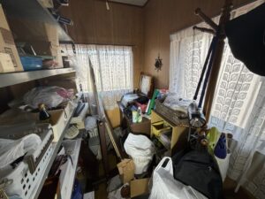 棚や箱、生活用品が置かれていた洋室