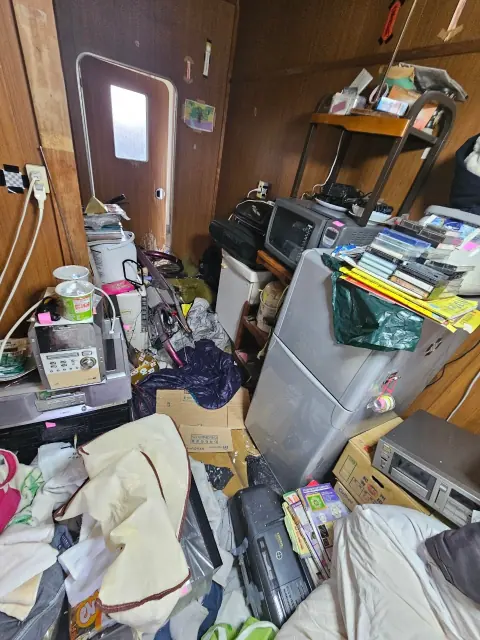 美濃市の5LDKのゴミ屋敷片付け事例の写真。家電や衣類、書籍があふれた室内